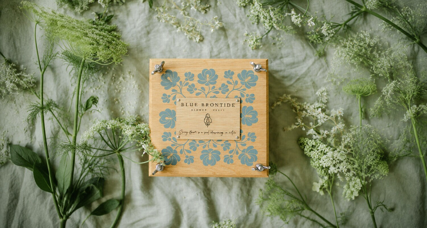 Folksy Floral wooden flower press surrounded by freshly gathered flowers