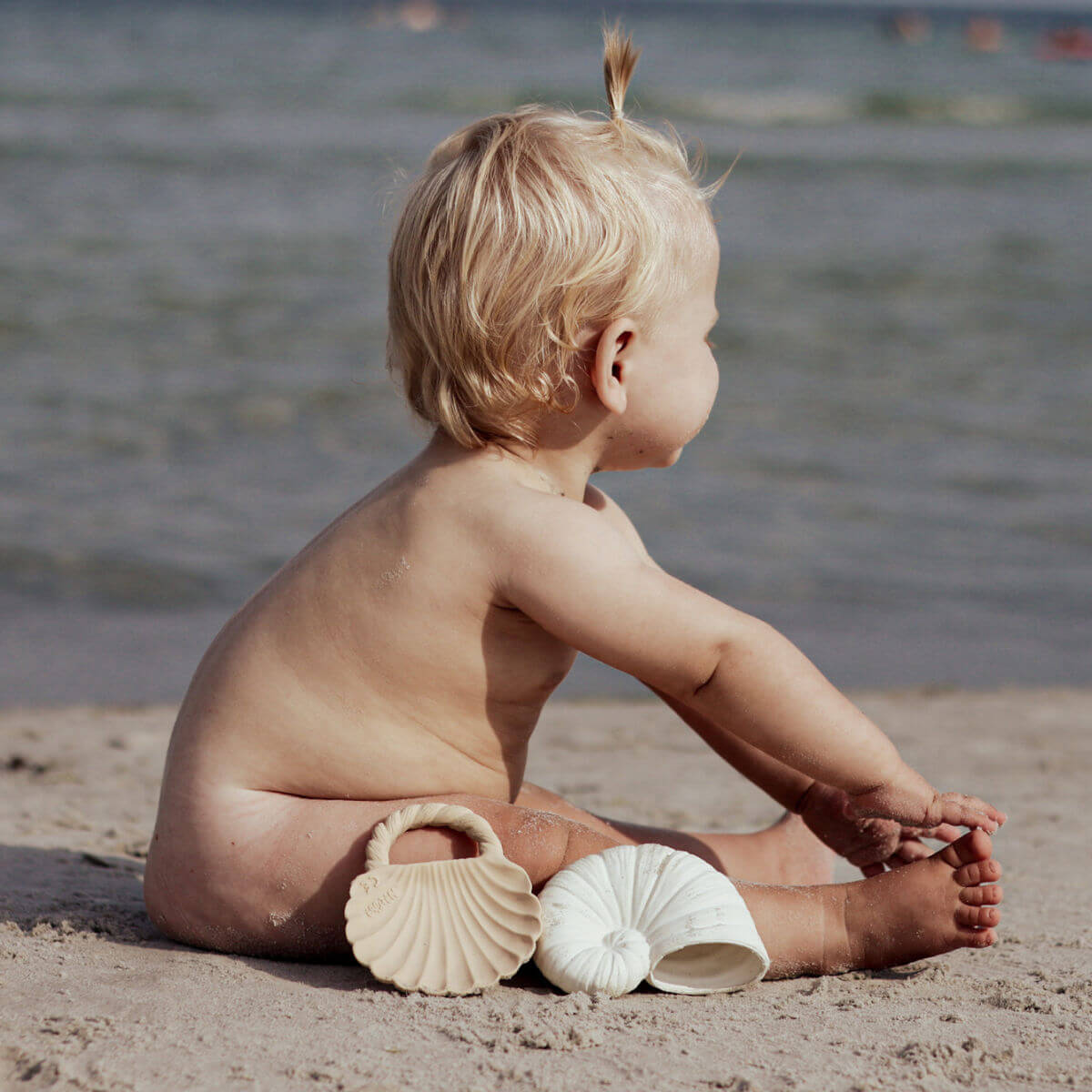 Baby sat with Natruba Ocean Shell bath toys on the beach – eco-friendly teething and water play toys for babies