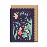 Woodland new baby greeting card with a scalloped dark navy border and a kraft paper envelope illustrated by Sister Paper Co. The card features whimsical floral artwork with bluebells, a bird, a small mouse in a red dress, flowers, and the text 'HELLO SWEET BABY'.
