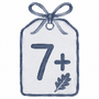 A watercolor-style gift tag illustration with a bow at the top, a large number 7, a plus sign, and a small leaf on a white background.