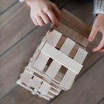 child playing with architectural wooden blocks by wooden story