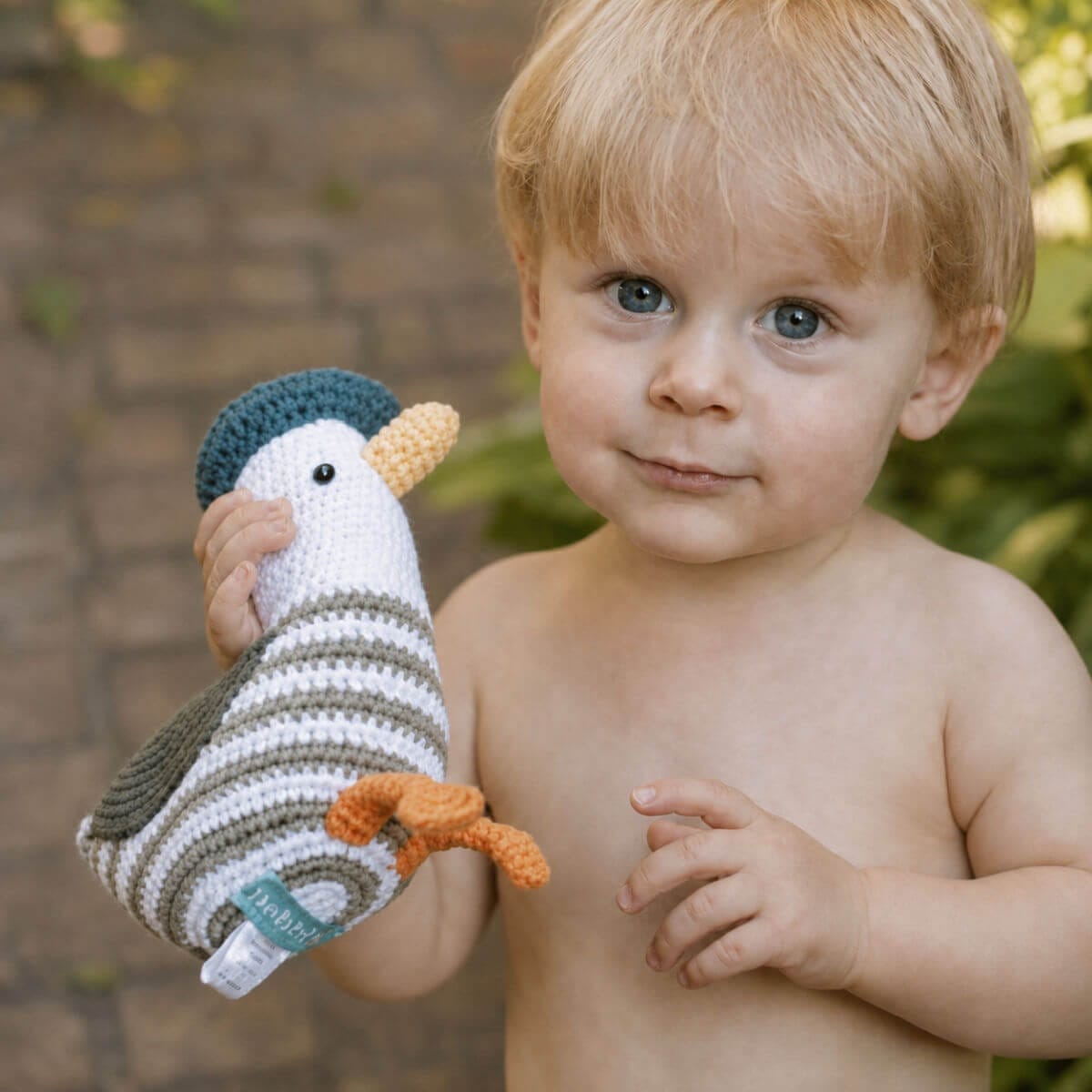 little boy playing outside with seagull baby rattle