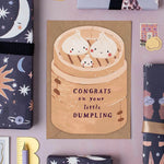 Card with dumpling illustration and 'Congrats on your little dumpling' text on a decorative background.