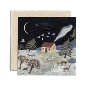 Greeting card with a winter scene featuring a cabin, trees, animals, and a night sky with stars and moon by British illustrator Gemma Koomen. 