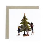 Greeting card with illustration of children decorating a Christmas tree with a star on top by Gemma Koomen