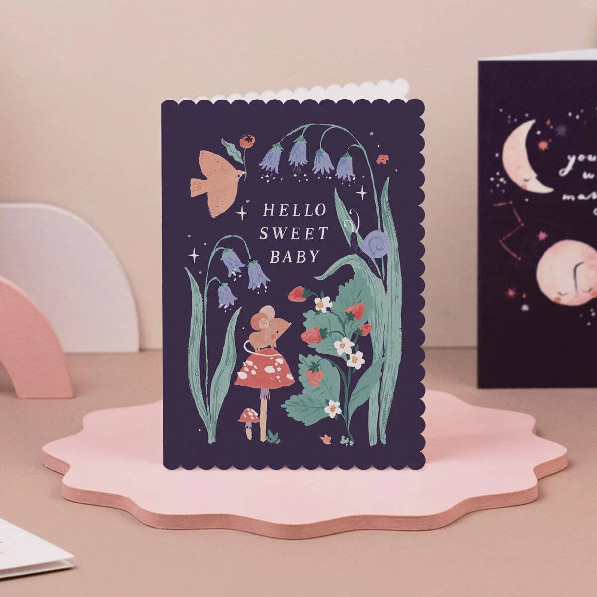 Sister paper co greeting card with floral design and 'Hello Sweet Baby' text on a pink stand.