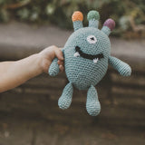 monster crochet soft wool baby rattle being held in baby hand
