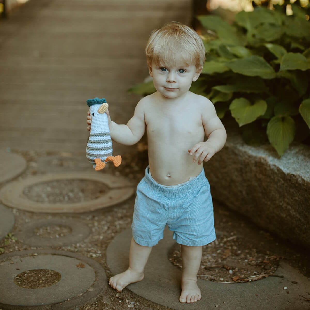 seagull baby rattle handmade by pebblechild being played with outside with  little boy