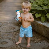 little barefoot boy playing outside with seagull baby rattle