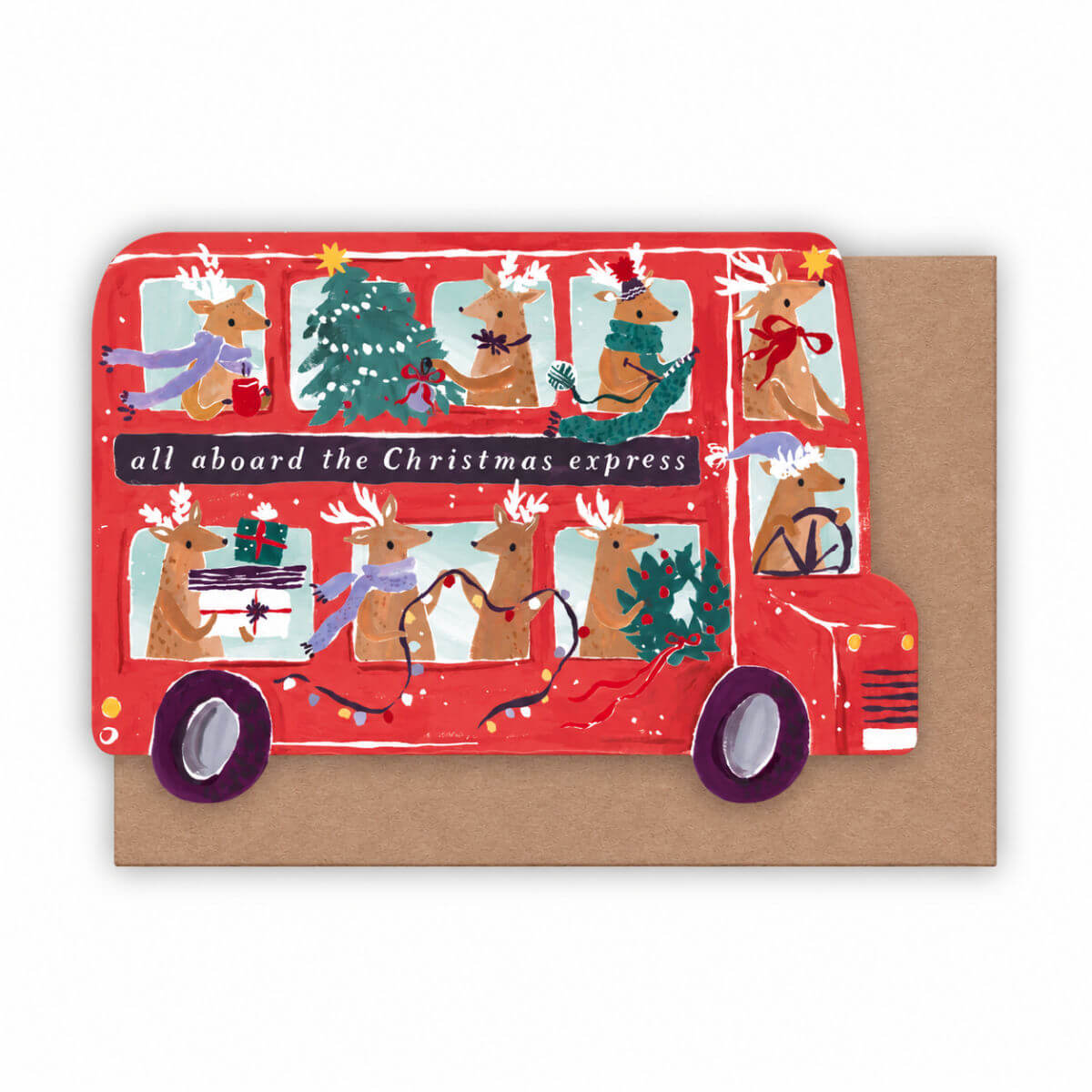 A Christmas-themed double-decker bus card or print featuring illustrated reindeer passengers, holiday decorations, and the text 'all aboard the Christmas express,' shown in front of a brown kraft envelope on a white background by sister paper co.