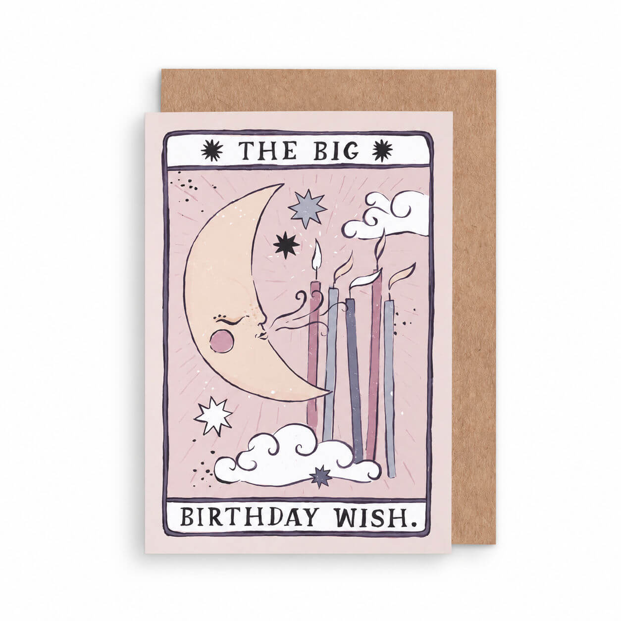 A tarot-style birthday card with a kraft envelope behind it. The card illustration shows a crescent moon, stars, clouds, and lit candles on a pale pink background, with the text 'THE BIG BIRTHDAY WISH by sister paper co.