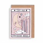 A tarot-style birthday card with a kraft envelope behind it. The card illustration shows a crescent moon, stars, clouds, and lit candles on a pale pink background, with the text 'THE BIG BIRTHDAY WISH by sister paper co.