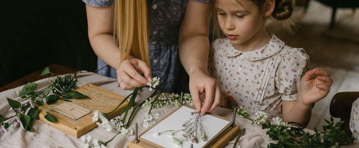 A family using a Blue Brontide wooden flower press