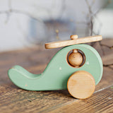 Wooden toy helicopter on wooden table handmade by friendly toys